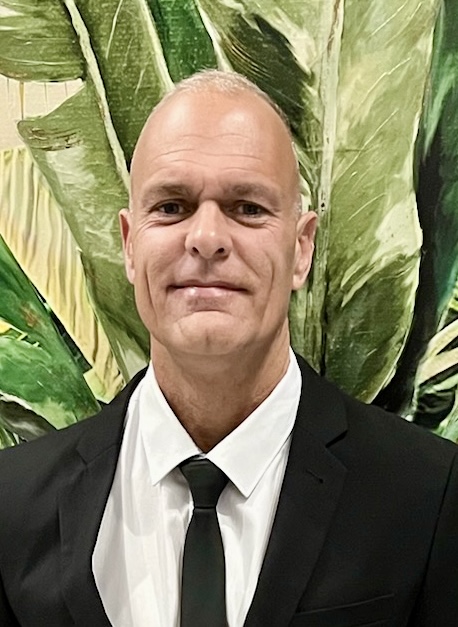 Man in suit against leafy background